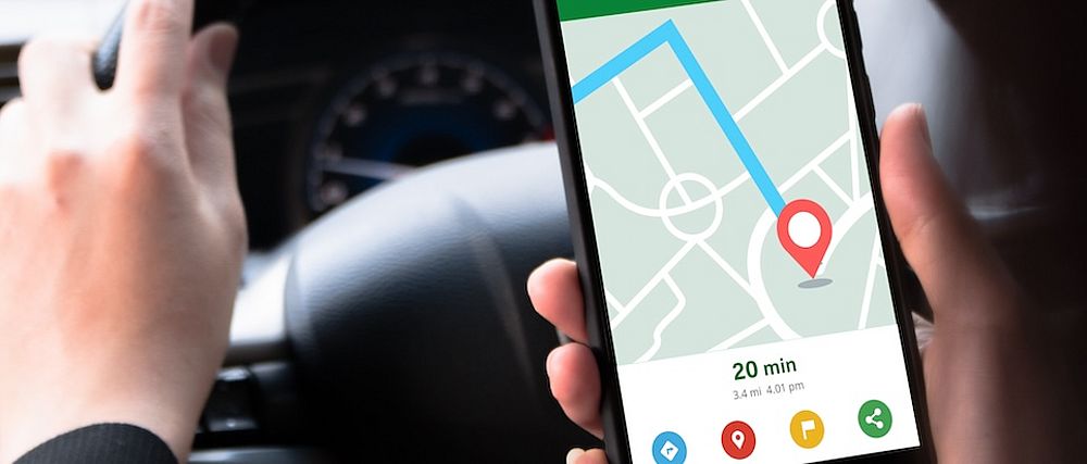 Eine Person hält ein Smartphone in der Hand, das einen Online-Kartendienst anzeigt.